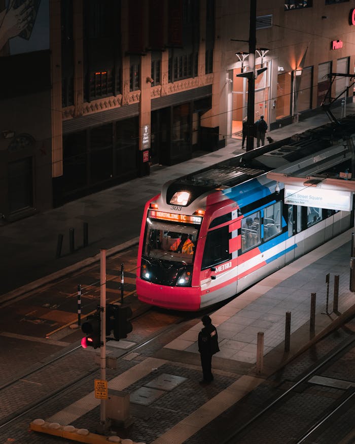 Tram in downtown Houston at night, vibrant urban transportation scene.